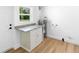 Utility room with gray marble countertop, cabinet storage, and wood-look flooring at 36 Morning Glory Dr, Debary, FL 32713