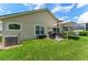 Backyard with well-maintained lawn, patio with seating, grill, and a screened lanai at 462 Lakepark Trl, Oviedo, FL 32765
