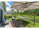 Serene backyard patio with hammock, umbrella, and seating, near a screened lanai at 462 Lakepark Trl, Oviedo, FL 32765