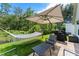 Inviting backyard patio with a hammock, shade umbrella, grill, and comfortable seating at 462 Lakepark Trl, Oviedo, FL 32765
