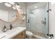 Beautiful bathroom with stone wall, glass shower and modern fixtures and round mirror at 462 Lakepark Trl, Oviedo, FL 32765