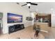 Open-concept living room with a TV and bar stools to the kitchen bar at 462 Lakepark Trl, Oviedo, FL 32765