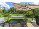 Relaxing backyard patio features a hammock, shade umbrella, and outdoor seating at 462 Lakepark Trl, Oviedo, FL 32765