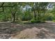 Circular driveway with a gravel surface surrounded by lush landscaping and mature trees at 4702 Shorecrest Dr, Orlando, FL 32817