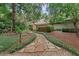 Inviting stone pathway leading to the home, framed by lush greenery and mature trees at 4702 Shorecrest Dr, Orlando, FL 32817