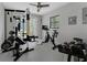 This well-lit home gym includes a full weight set, stationary bike, and ceiling fan at 4702 Shorecrest Dr, Orlando, FL 32817