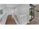 Bright hallway featuring wood floors, white walls, and natural light from the sunroom sliding doors at 4702 Shorecrest Dr, Orlando, FL 32817