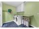 Well-lit laundry room with modern washer and dryer, counter space, and vibrant blue-patterned floor at 4702 Shorecrest Dr, Orlando, FL 32817