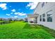 Spacious backyard with lush green grass and covered patio, overlooking a picturesque lake at 4908 Lotta Ct, St Cloud, FL 34772