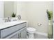 A well-lit half-bathroom features a gray vanity, modern fixtures, and tasteful decorations at 4908 Lotta Ct, St Cloud, FL 34772