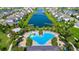 Aerial shot of a community pool featuring a splashpad, palm trees, and lots of lounge chairs at 4908 Lotta Ct, St Cloud, FL 34772