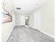 Hallway with multiple doors, carpet, and hanging artwork at 4908 Lotta Ct, St Cloud, FL 34772