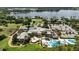 Aerial view of community clubhouse, pools, golf course, and lake with mature trees and lush landscaping throughout at 5074 Isleworth Country Club Dr, Windermere, FL 34786