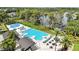 Aerial view of the community pool and splashpad with lounge chairs and tables and the lake in the background at 5074 Isleworth Country Club Dr, Windermere, FL 34786