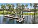 Community boat dock with a boat tied up to the dock, a lake view, mature trees, and the community pool in the background at 5074 Isleworth Country Club Dr, Windermere, FL 34786