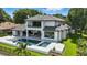 Stunning two-story home with a pool, jacuzzi, covered patio, mature trees, and lush landscaping in the backyard at 5074 Isleworth Country Club Dr, Windermere, FL 34786