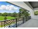 A covered balcony boasts decorative iron railings and overlooks the lush green landscaping at 5074 Isleworth Country Club Dr, Windermere, FL 34786