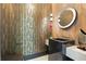 A modern bathroom with unique golden wallpaper, stylish vanity and rounded mirror with art deco design at 5074 Isleworth Country Club Dr, Windermere, FL 34786