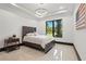 Serene bedroom with a cozy bed, minimalist decor, and a window overlooking a lush garden at 5074 Isleworth Country Club Dr, Windermere, FL 34786