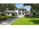 Gorgeous two-story home with a black tile roof, manicured lawn, and a paver driveway, with a purple vehicle parked in front at 5074 Isleworth Country Club Dr, Windermere, FL 34786