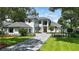 Breathtaking two-story home with manicured lawn, gray tile roof, lush landscaping, and a paver driveway at 5074 Isleworth Country Club Dr, Windermere, FL 34786