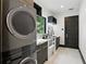 Well-equipped laundry room with modern washer/dryer, marble countertops, ample storage, and a bright window at 5074 Isleworth Country Club Dr, Windermere, FL 34786