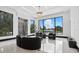 Living room with large windows overlooking the greenery and black modern-style furniture with light-colored flooring at 5074 Isleworth Country Club Dr, Windermere, FL 34786
