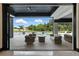 Covered outdoor patio featuring comfortable seating and a view of the pool and manicured backyard at 5074 Isleworth Country Club Dr, Windermere, FL 34786
