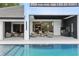 Relaxing covered patio with an outdoor kitchen overlooks a stunning in-ground pool at 5074 Isleworth Country Club Dr, Windermere, FL 34786