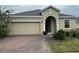 Charming single-story home featuring a brick driveway and a two-car garage at 512 Novara Way, Davenport, FL 33837