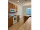 Modern kitchen with wooden cabinets, granite countertops, and a large window at 512 Novara Way, Davenport, FL 33837
