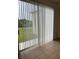 Enclosed patio area with vertical blinds and a serene view of the backyard at 512 Novara Way, Davenport, FL 33837