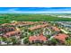 Aerial view of complex boasting tile roofs, lush landscaping, community lake, and central location at 5566 Metrowest Blvd # 10, Orlando, FL 32811