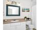 Bathroom featuring white vanity, framed mirror, and decorative seashell wall art at 5566 Metrowest Blvd # 10, Orlando, FL 32811