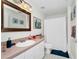 Bright bathroom featuring a single sink vanity, framed mirror, and a shower with a white curtain at 5566 Metrowest Blvd # 10, Orlando, FL 32811