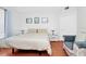 Cozy bedroom with a comfortable bed, wood floors, and a sitting area with a modern chair at 5566 Metrowest Blvd # 10, Orlando, FL 32811