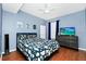 Stylish bedroom with a contrasting color scheme, wood floors, and a modern dresser with a TV at 5566 Metrowest Blvd # 10, Orlando, FL 32811