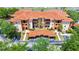 Eye-level view showcasing the building's facade with tiled roofs, garages, and landscaping at 5566 Metrowest Blvd # 10, Orlando, FL 32811
