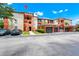 Exterior view of condo complex with terra cotta accents, garages and well-maintained landscaping at 5566 Metrowest Blvd # 10, Orlando, FL 32811