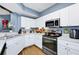 This kitchen features white cabinets, stainless appliances, and under-cabinet lighting at 5566 Metrowest Blvd # 10, Orlando, FL 32811
