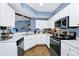 Bright kitchen featuring white cabinets, stainless steel appliances, and a convenient corner layout at 5566 Metrowest Blvd # 10, Orlando, FL 32811