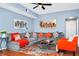 Comfortable living room with gray sectional couch, orange pillows and chair, and unique area rug at 5566 Metrowest Blvd # 10, Orlando, FL 32811