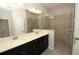 Modern bathroom featuring a dual vanity, quartz countertops, and a tiled glass shower at 5709 Gingham Dr, Kissimmee, FL 34758