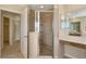 Bright bathroom featuring a tile shower with glass doors and a makeup vanity area at 5819 Covington Cove Way, Orlando, FL 32829