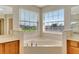 Corner soaking tub with two windows providing ample natural light and neighborhood views at 5819 Covington Cove Way, Orlando, FL 32829