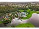 Aerial view of a resort-style community pool with lush landscaping and lakeside setting at 5819 Covington Cove Way, Orlando, FL 32829