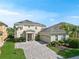 Charming two-story home with lush landscaping and a brick paver driveway at 5819 Covington Cove Way, Orlando, FL 32829