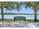 Peaceful lake view with a park bench under shady trees, providing a tranquil spot for relaxation and enjoying the scenery at 5819 Covington Cove Way, Orlando, FL 32829
