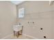 Functional laundry room with utility sink, shelving, and tile flooring at 5819 Covington Cove Way, Orlando, FL 32829