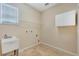 Laundry area featuring a sink, shelving, tile flooring and white cabinet at 5819 Covington Cove Way, Orlando, FL 32829